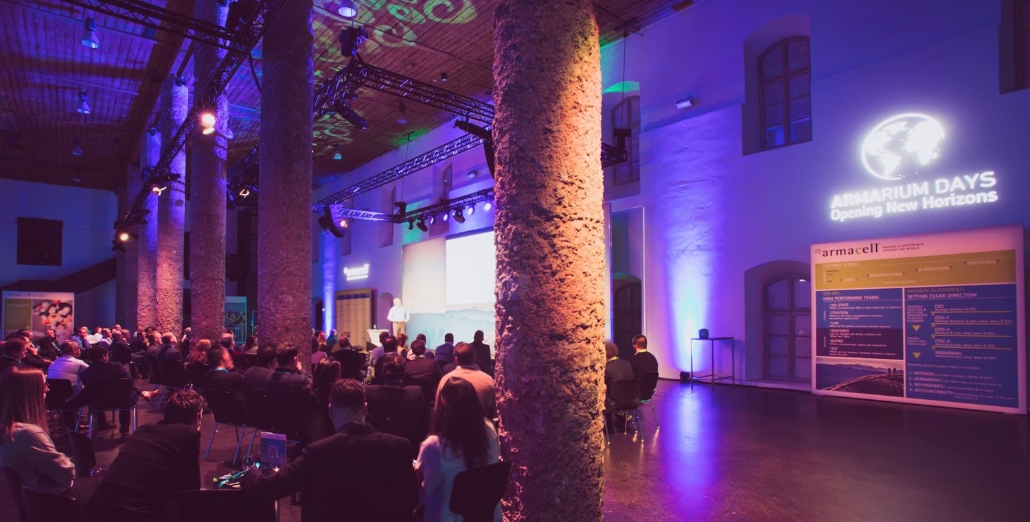 Saal der Armacell Armarium Days als Publikumsbereich mit Blick auf Bühne, Leinwand und professionelles Corporate-Event-Setup.
