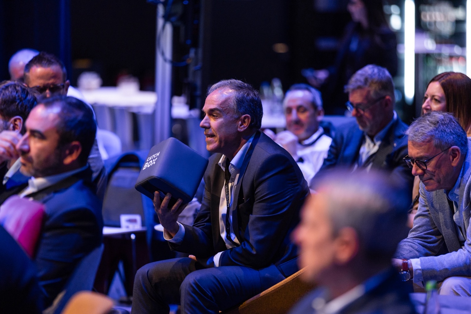 Interaktives Konferenzformat bei der MBGDC 2024 Teilnehmer hält eine Catch Box während eines interaktiven Formats der Mercedes-Benz General Distributor Conference 2024.