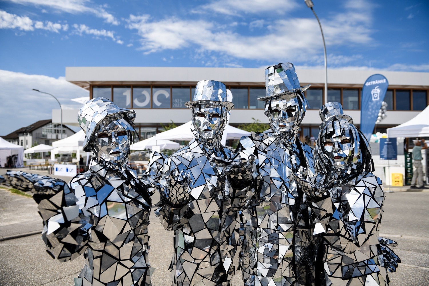 Performers in futuristic costumes featuring reflective polygons providing entertainment at the Mission Future event