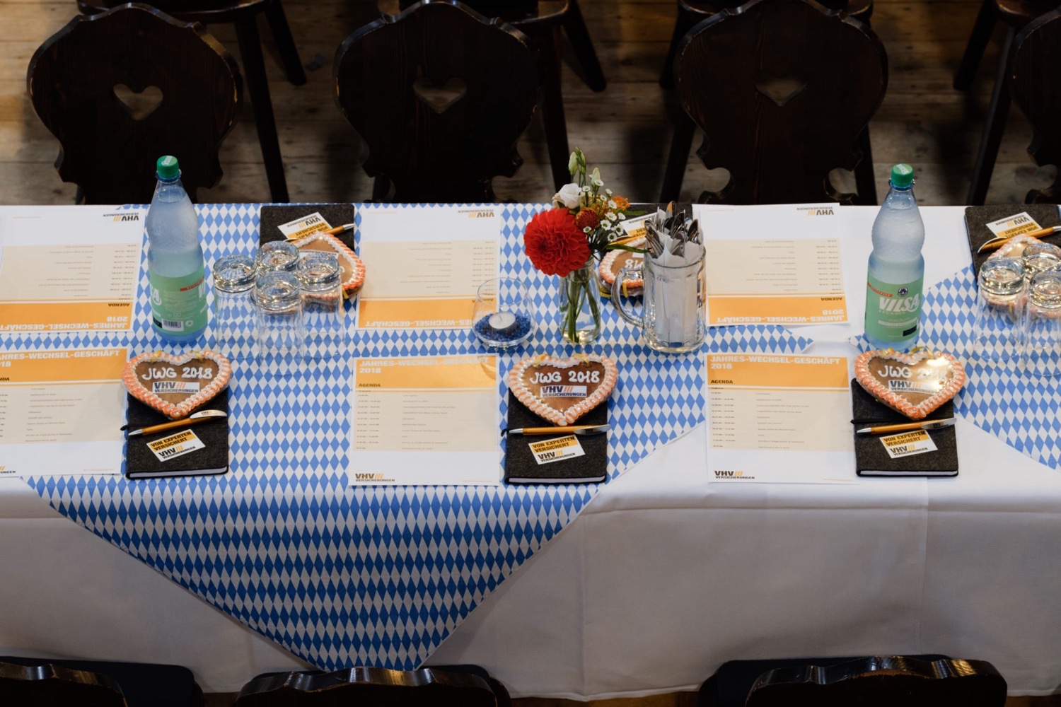 Oktoberfest-Dekoration für VHV Mitarbeiterveranstaltung Gedeckte Oktoberfest-Tische mit blau-weißem Rautenmuster, VHV Lebkuchenherz und festlicher Dekoration