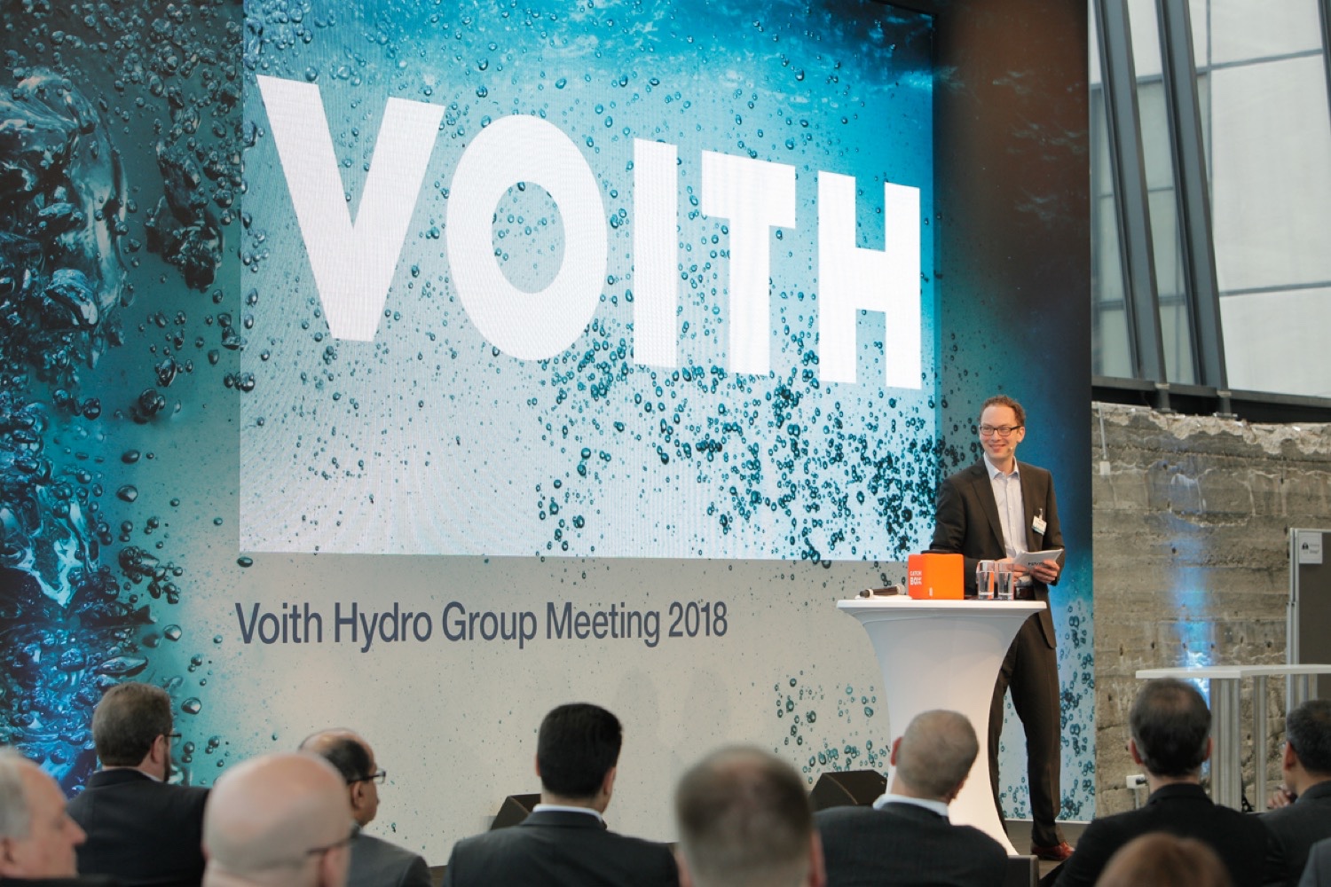 Moderierte Bühne der VOITH HYDRO Führungskräftetagung Moderator führt auf der Bühne durch die internationale Führungskräftetagung zu Strategie und Kulturwandel