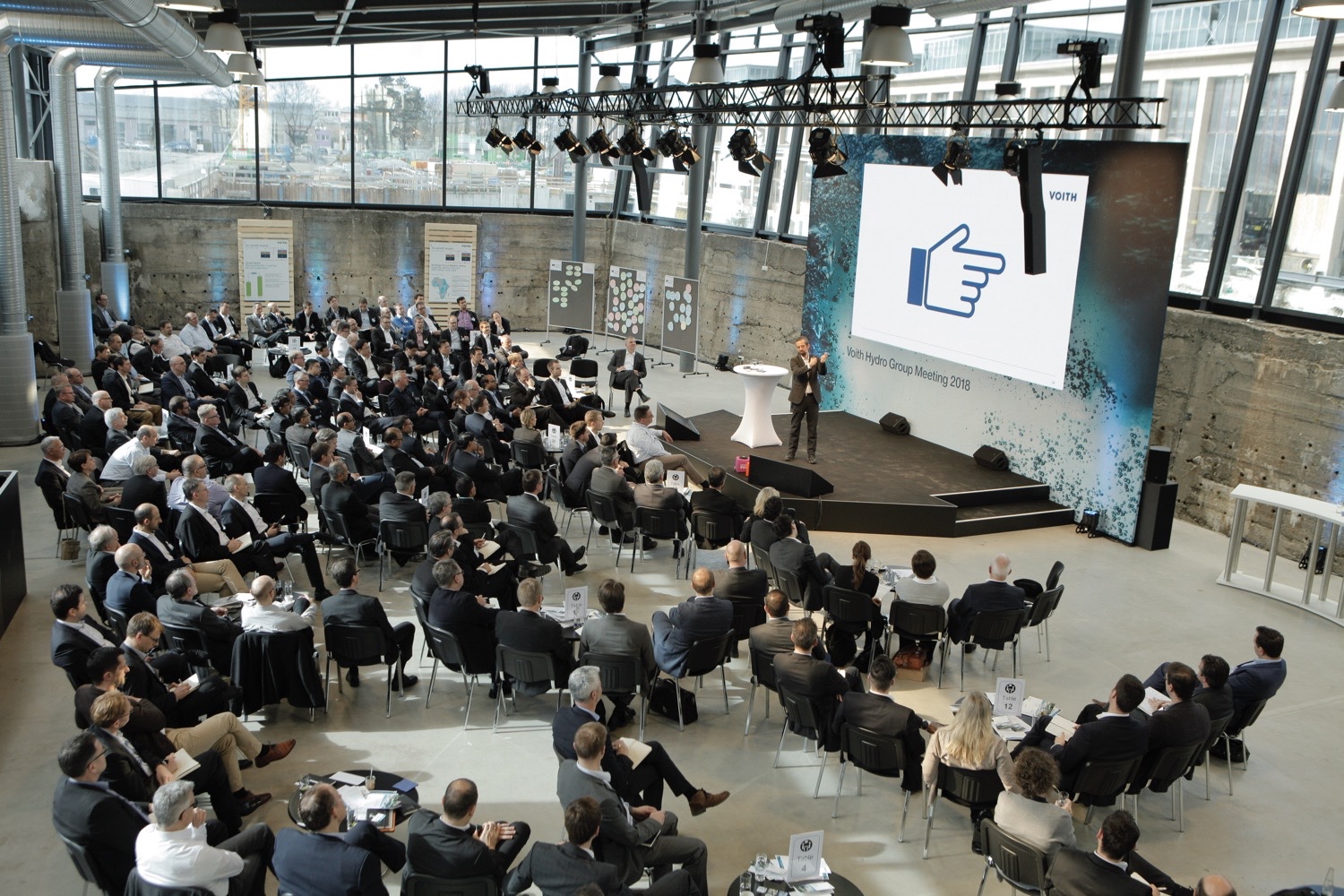 Blick von oben auf Publikum, Bühne und Redner bei der VOITH HYDRO Führungskräftetagung in München